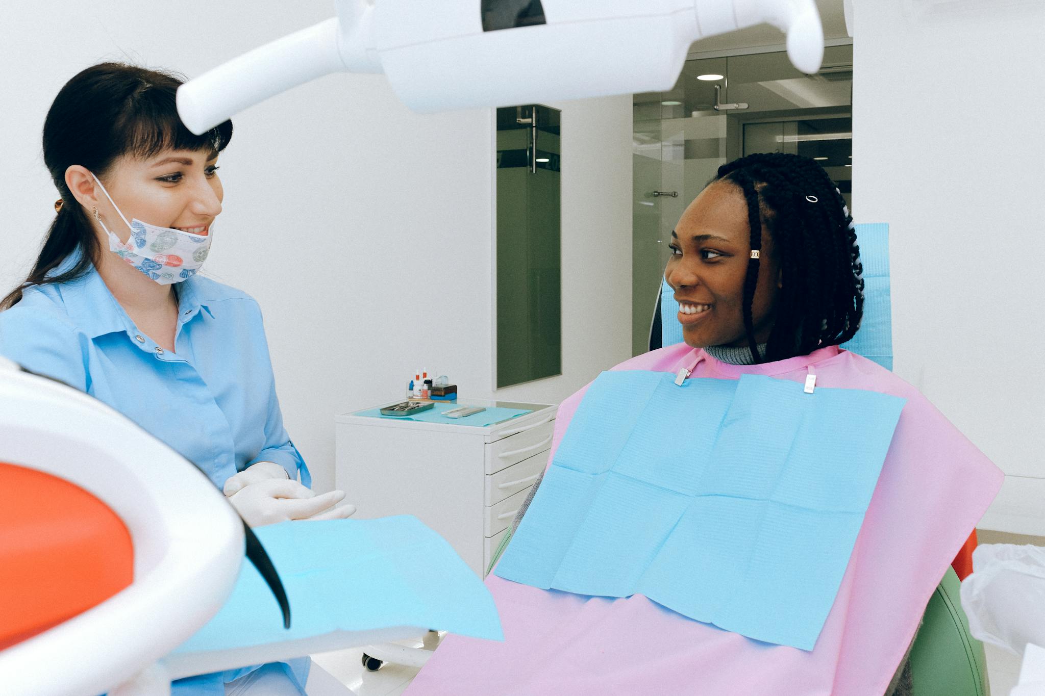A dentist and patient share a warm conversation during a dental check-up.